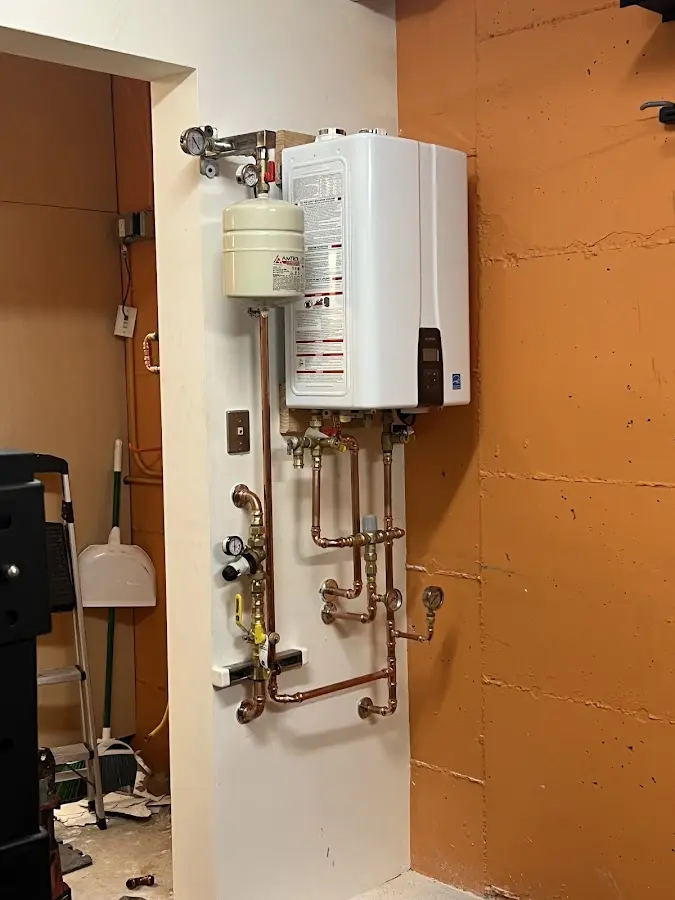 Plumbing technician inspecting water heater connections in Horace